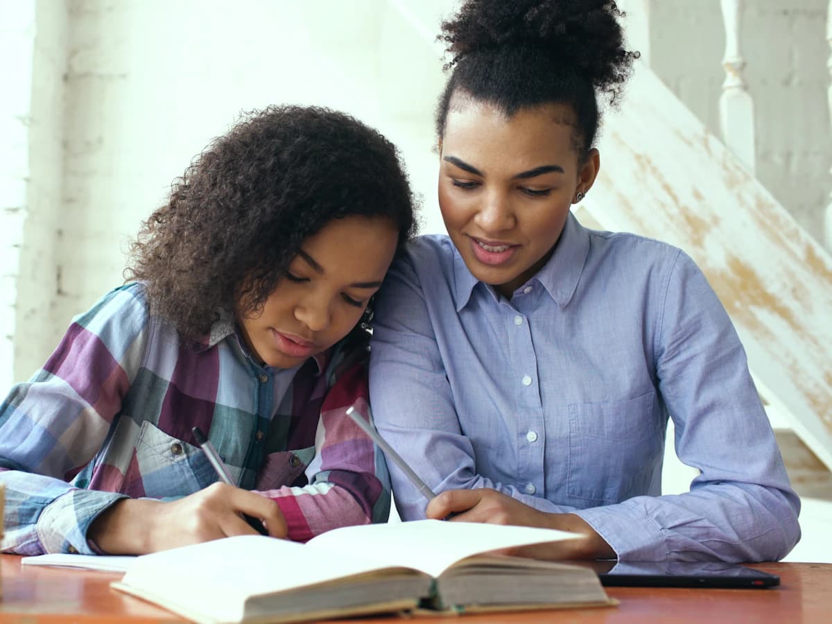 أمّ تذاكر مع ابنتها على طاولة الدراسة